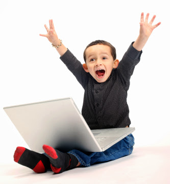 a young mixed race boy shouts with delight whilst using a laptop computer