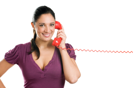Young casual woman holding a red receiver and smiling at the phone call